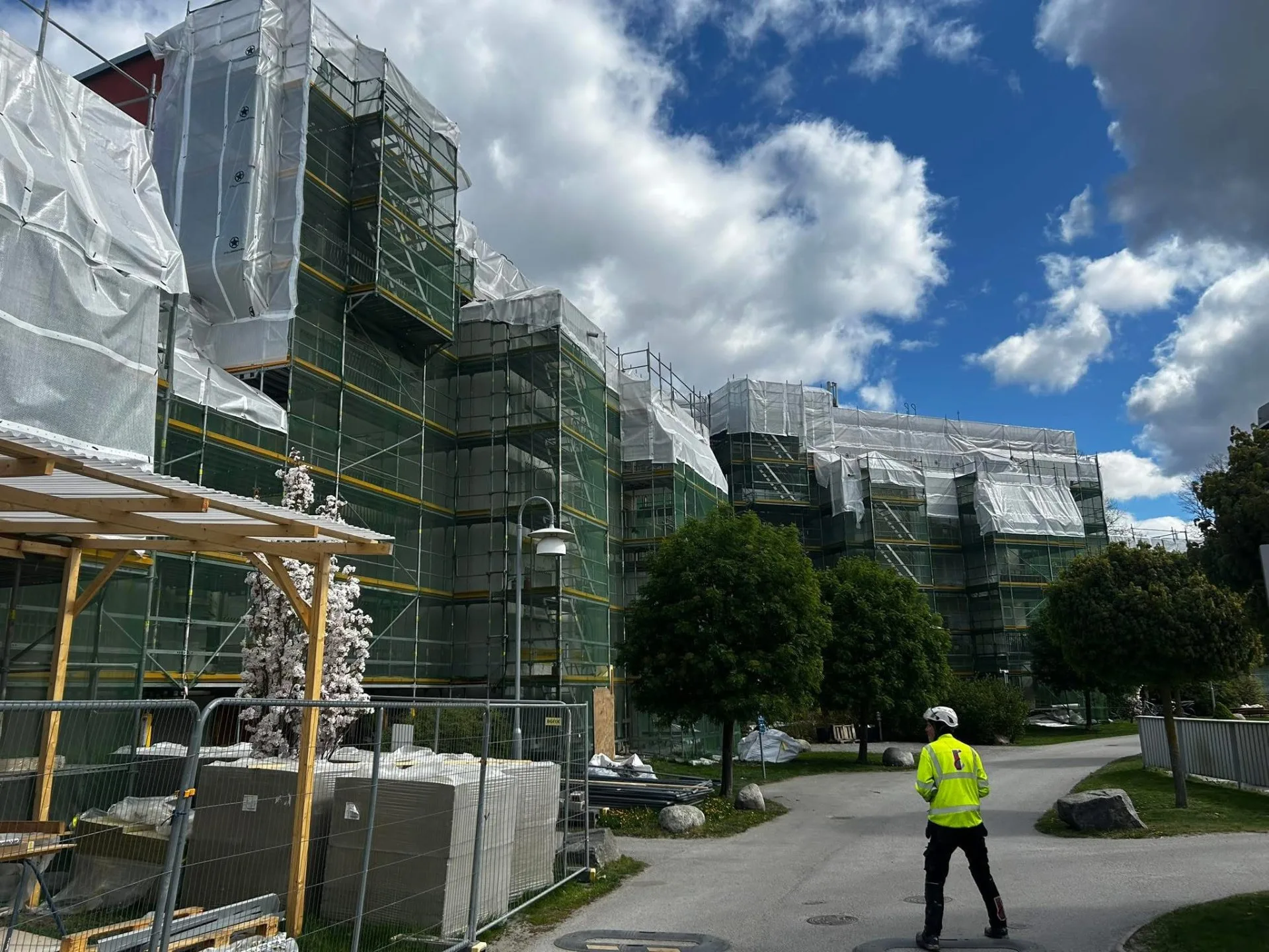 Fastighet inklädd i ställning och väderskydd under takbyte